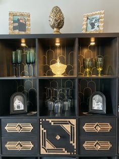 a black and gold bookcase with glass vases on the top, next to other items