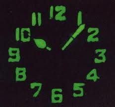 a black clock with green numbers on it