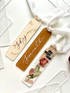 two tags with writing on them sitting next to some scissors and other items that are laying around