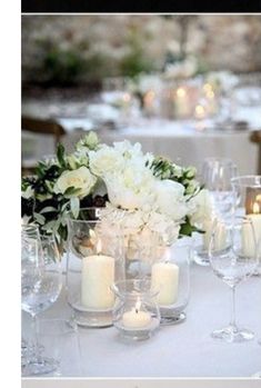 the table is set with white flowers and candles