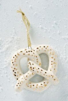 a white ornament hanging from a string on a snow covered surface with dots