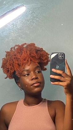 a woman with red hair is holding up her cell phone to take a selfie