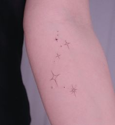 a woman's arm with three small stars on the left side of her arm