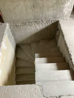 concrete stairs going up to the top of an unfinished building with cement walls and flooring