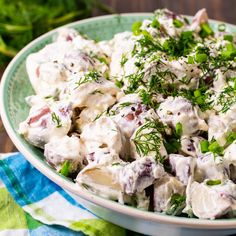 a close up of a salad in a bowl on a table with green napkins