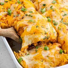 a casserole dish with cheese and green onions on the side, ready to be eaten