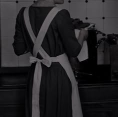 a woman standing in front of a stove cooking food