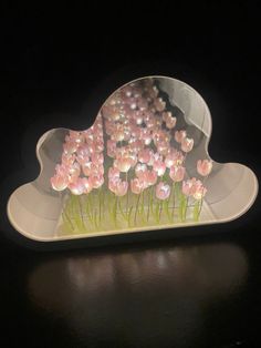 there are many pink flowers in the shape of a cloud on top of a table