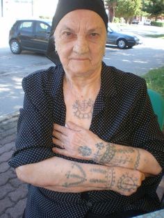 an older woman with tattoos on her arms