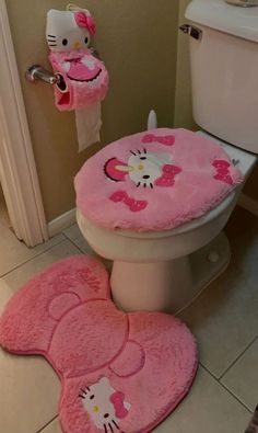 a bathroom with hello kitty rugs on the floor and a toilet in the background