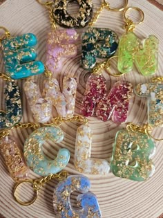 a bunch of different colors and designs on a gold plated keychain that is sitting on a table