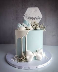 a blue and white cake with bow ties on it