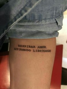 a person with a tattoo that reads restrar amo aspirado liberade