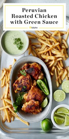 chicken with green sauce served in a bowl and surrounded by french fries, lime wedges and cilantro