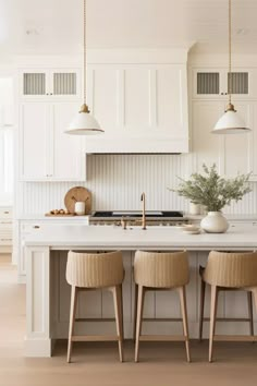 three chairs sit at the center of a kitchen island with white cabinets and counter tops