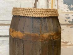 an old wooden barrel with rope on top