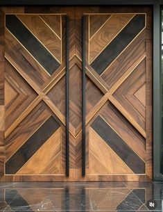 a modern wooden door with black and gold trimmings on the front entrance to a house