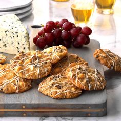 cookies with cheese and grapes on a cutting board