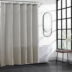 a white bath tub sitting under a bathroom mirror next to a sink and shower curtain