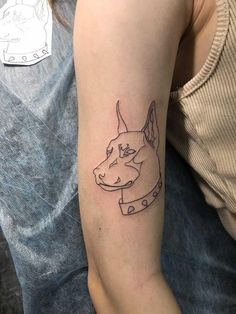 a woman with a tattoo on her arm has a dog's head drawn on it