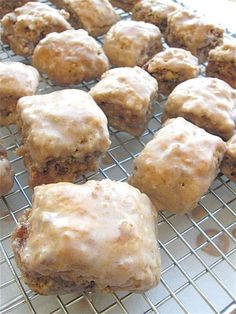 a bunch of doughnuts that are sitting on a cooling rack with icing