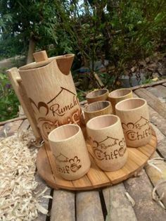 a wooden tray with six cups on it