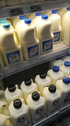 milk bottles are stacked on shelves in a grocery store