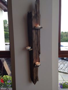 a piece of wood that has some candles in it on the side of a wall