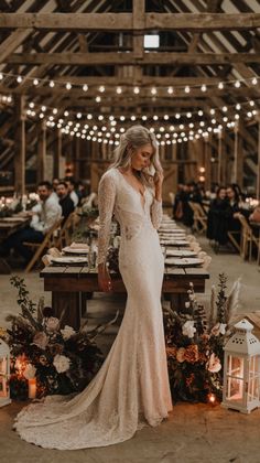 Transform a rustic barn into a magical venue with delicate lights, earthy tones, and timeless lace. This bride’s long-sleeve gown adds sophistication to the cozy ambiance, making it a wedding to remember. #countrywedding #rusticbride2025