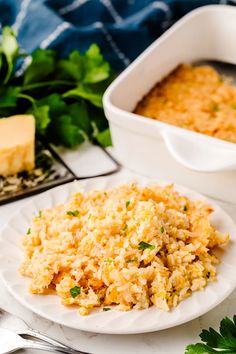 a plate with rice and parsley next to a casserole dish