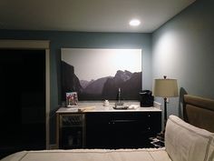 a bed sitting in a bedroom next to a painting