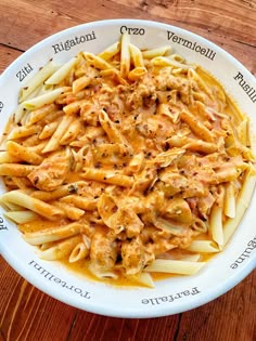 pasta with sauce and meat in a white bowl on a wooden table, ready to be eaten