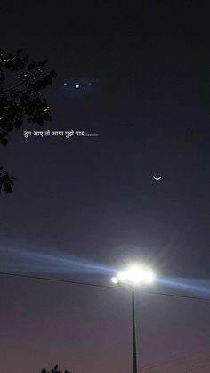 a street light with the moon in the background