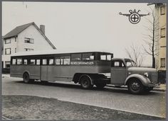 an old bus is parked on the side of the road in front of a building