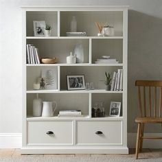 a white bookcase filled with lots of books