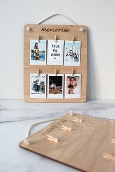 a wooden board with photos pinned to it on a marble counter top next to a mouse pad