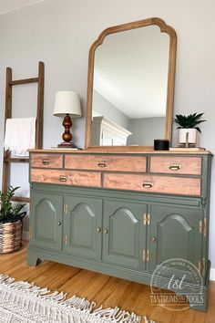 an old dresser is painted green and has a large mirror on the top with gold trim