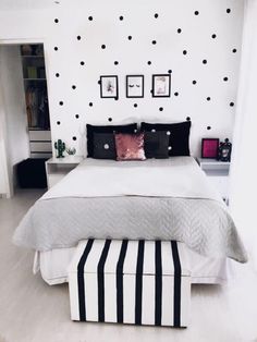 a bedroom with black and white polka dots on the wall above the bed is shown