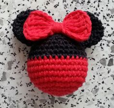 a crocheted mickey mouse hat with a red bow on it's head