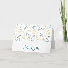 a thank you card sitting on top of a table next to a vase with flowers