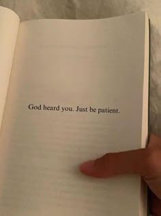 someone is holding an open book with the words god heard you just be patient