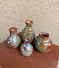 three small vases sitting on top of a table