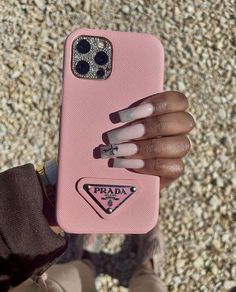 a woman's hand holding up a pink phone case