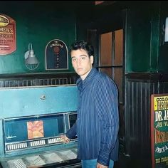 a man standing in front of an old piano