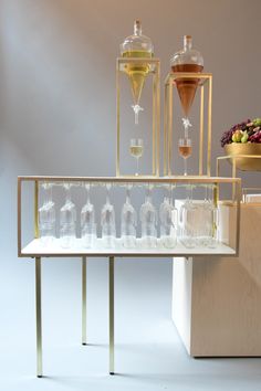 a table topped with lots of glasses filled with liquid