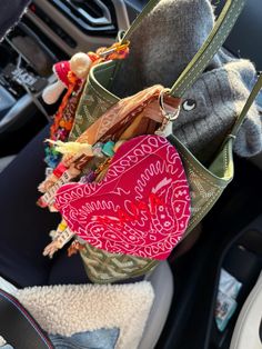 a stuffed animal sitting in the back seat of a car next to a handbag