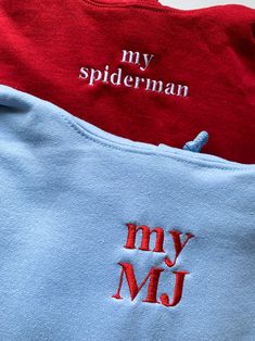 two red and blue shirts with the words my spiderman written on them are laying next to each other