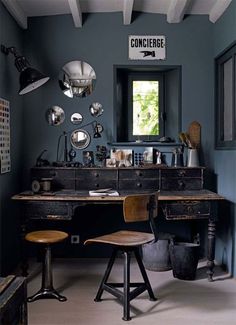 an old fashioned desk and chair in a room with blue walls, white beams and wooden floors