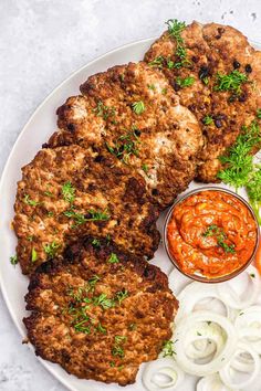 a white plate topped with meat patties and sauce