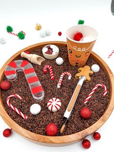 a wooden bowl filled with candy canes and candies